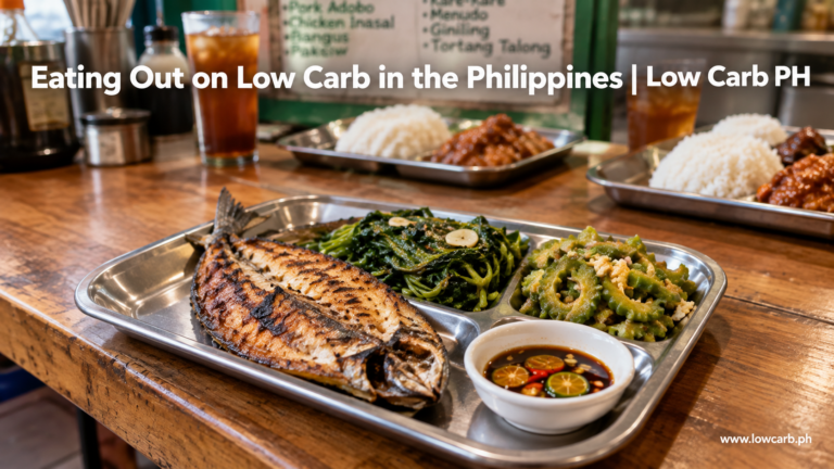 A low carb carinderia tray of grilled fish and vegetables with no rice, next to a typical default plate with rice and iced tea in the background.